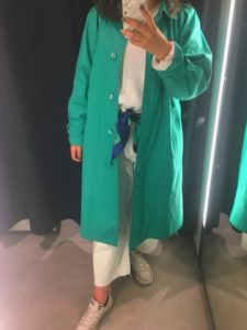 発色の良いグリーンスプリングコートを着用した女性の画像