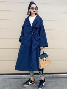 ボリュームのあるネイビースプリングコートを着用した女性の画像